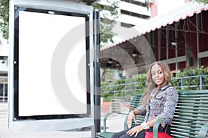 Woman sitting at a bus stop bench