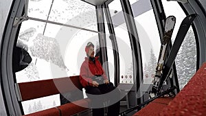 A woman sitting on a Cable car during a snow storm