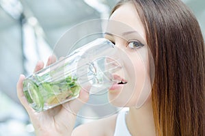 Woman is sitting in cafe with cocktail