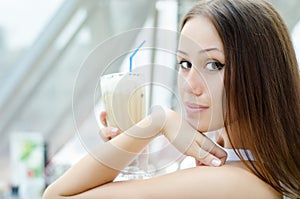 Woman is sitting in cafe with cocktail