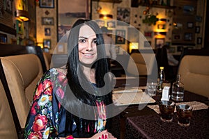 Woman sitting at the cafe and drinking coctail