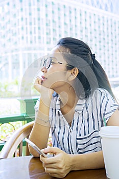 Woman sitting in cafe while holding mobile phone