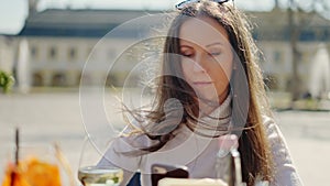 Woman sitting in cafe outdoor with phone