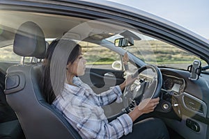 woman sitting in a car and holding on to the steering wheel