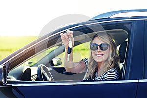 Woman sitting in the car and holding a white blank poster.