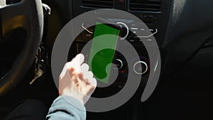 Woman sitting in car and using her phone with vertical green screen