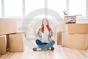 Woman sitting among cardboard boxes, housewarming photo