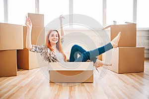 Woman sitting in carton box, housewarming photo