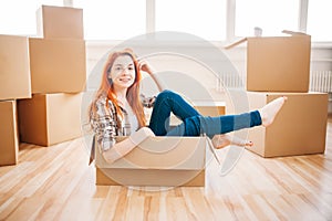 Woman sitting in carton box, housewarming photo