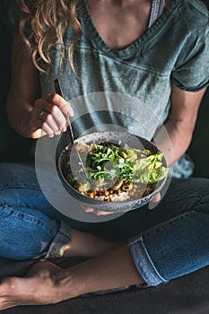 Woman sitting on chair andeating healthy superbowl