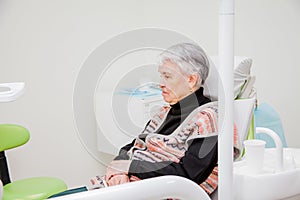 Woman is sitting in a chair at a dentist`s reception