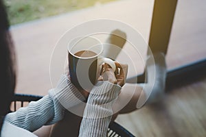 Woman sitting on chair and drinking hot coffee in bedroom at home,Relaxing time,Close up