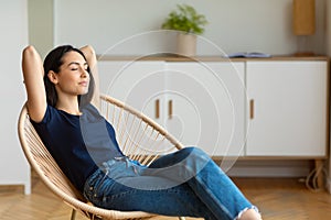 Woman Sitting In Chair With Eyes Closed Resting At Home