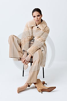 woman sitting on a chair fashionable autumn clothing luxury