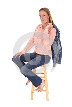 Woman sitting on chair, jacket over shoulder