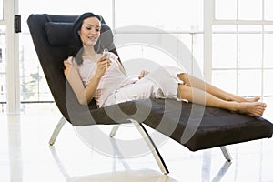 Woman sitting in chair listening to MP3 player