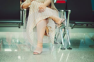 A woman is sitting on a chair in the waiting room.