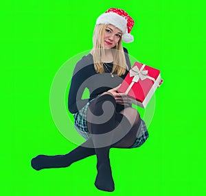 Woman sitting with Christmas hat and present in isolated background