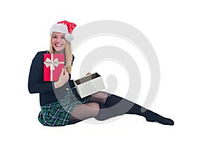 Woman sitting with Christmas hat and present in isolated background