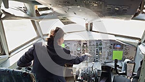 A woman is sitting in the cockpit of an airplane