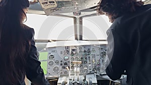 A woman is sitting in the cockpit of an airplane