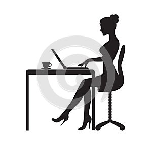 The woman is sitting at the computer