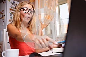 Woman sitting with computer and have strong surprise on face