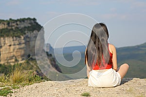 Woman sitting contemplating views in the mountain