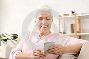 Woman Sitting on Couch Looking at Cell Phone