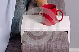 Woman sitting on the couch stand of cup in the hands of a cup