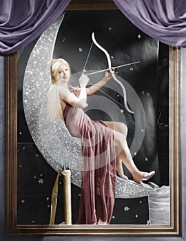 Woman sitting on crescent moon with bow and arrow