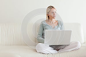 Woman sitting cross legged on the couch with her laptop