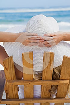 Woman sitting in deck chair at the beach