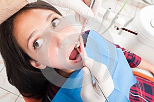Woman sitting in dentist chair being checked by doctor