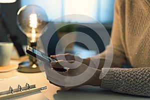 Woman sitting at desk and connecting with her phone