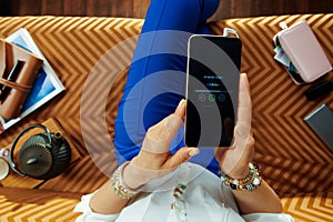 Woman sitting on divan in modern living room listening to music