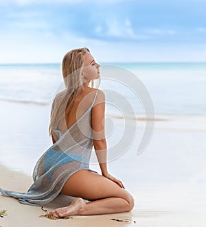 Woman sitting on the Dominican white sand beach