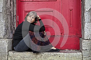 Woman sitting on door stoop