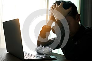 Woman sitting down, his face unsettled. At the computer desk she has headaches and stress. Cause of hard work and insufficient