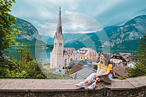 woman sitting and enjoying the vie of hallstatt austria