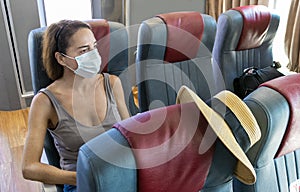 Woman sitting on ferry ship with a surgical mask during Covid-19 travelling in Greece