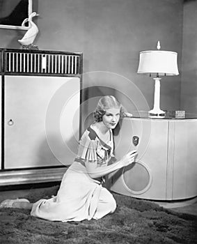 Woman sitting on the floor listening to her radio