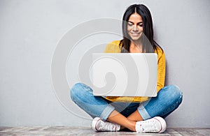 Woman sitting on the floor and using laptop