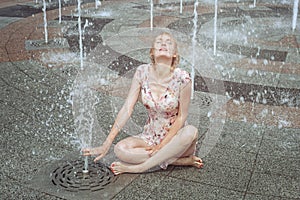 Woman is sitting in a fountain.