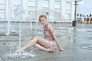 Woman is sitting in a fountain.