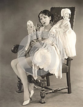Woman sitting with four dolls