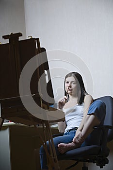 Woman Sitting In Front Of Easel