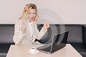 Woman sitting in front of laptop and showing like