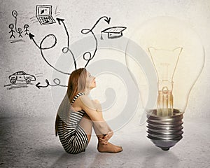 Woman sitting in front of light bulb thinking has many thoughts life ideas