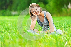 Woman sitting on green meadow